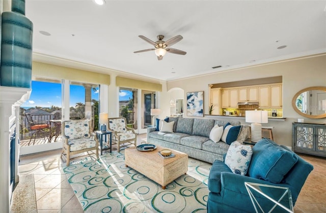 living room with ceiling fan, crown molding, and light tile patterned flooring