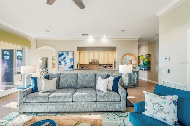 living room featuring ceiling fan, light tile patterned floors, and ornamental molding