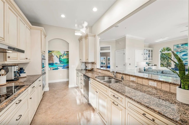 kitchen with cream cabinetry, sink, and stone countertops