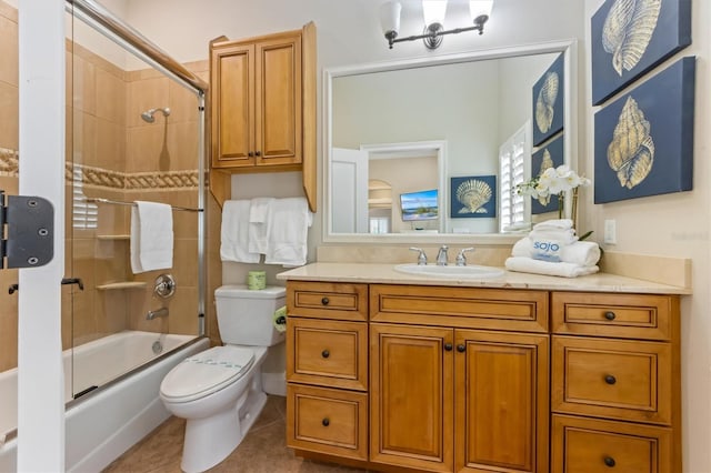 full bathroom with bath / shower combo with glass door, tile patterned floors, vanity, and toilet