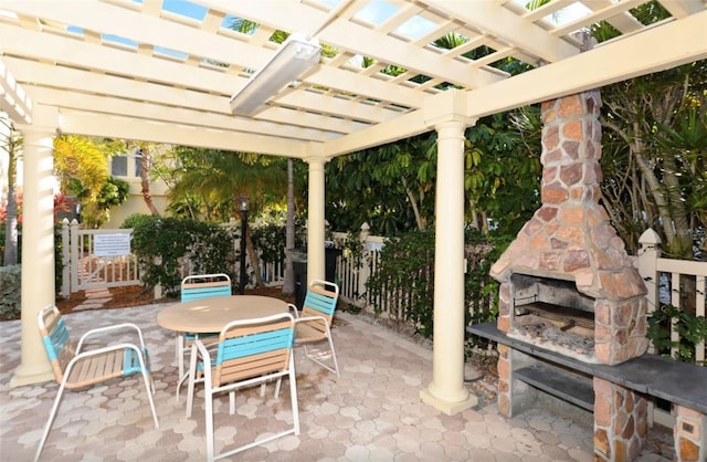 view of patio / terrace with a pergola and an outdoor stone fireplace