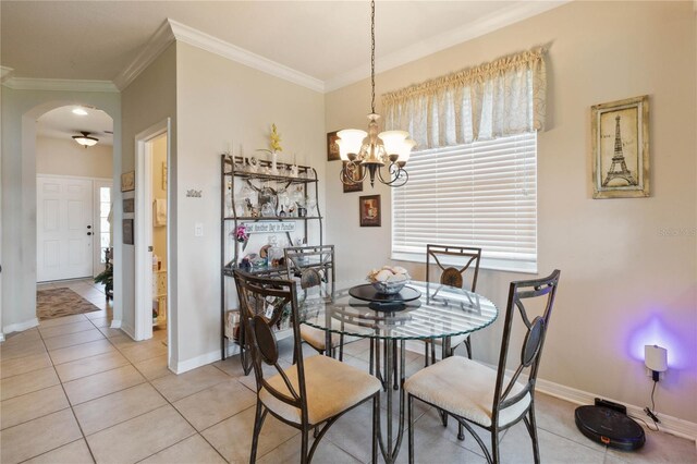 tiled dining area with crown molding and an inviting chandelier