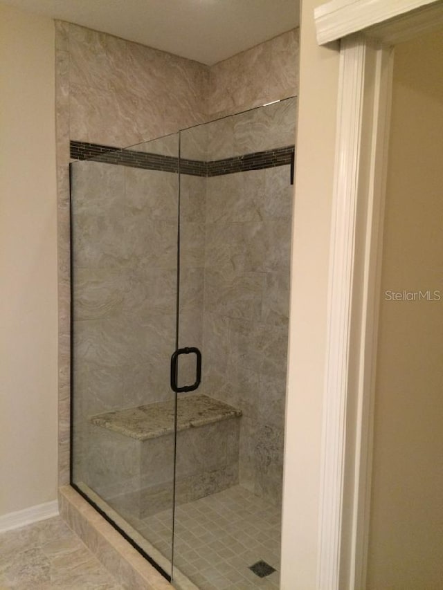 bathroom featuring a shower with door