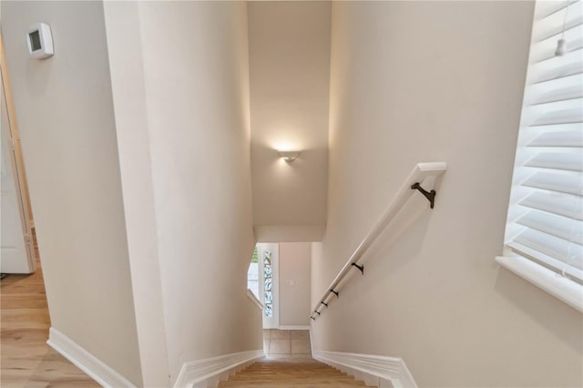 stairway with baseboards and wood finished floors