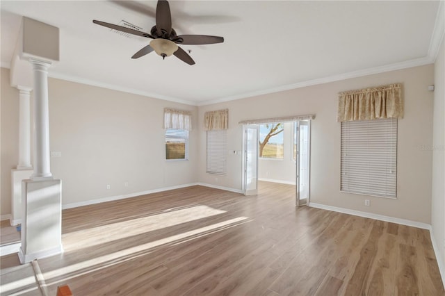 empty room with baseboards, ornate columns, ceiling fan, light wood-style floors, and crown molding