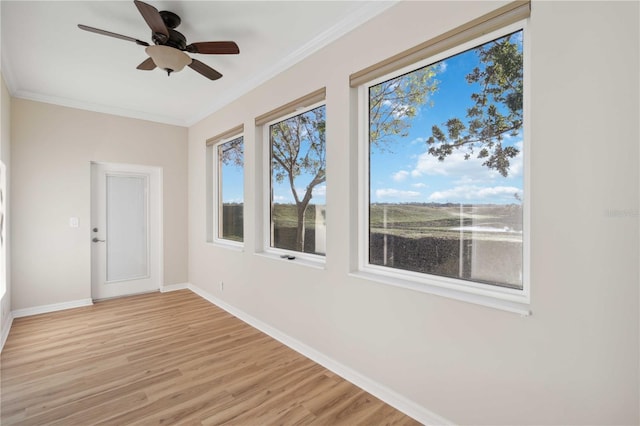 spare room featuring ceiling fan, baseboards, light wood-style floors, and ornamental molding