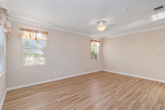 spare room with light wood-style flooring, a ceiling fan, visible vents, and ornamental molding