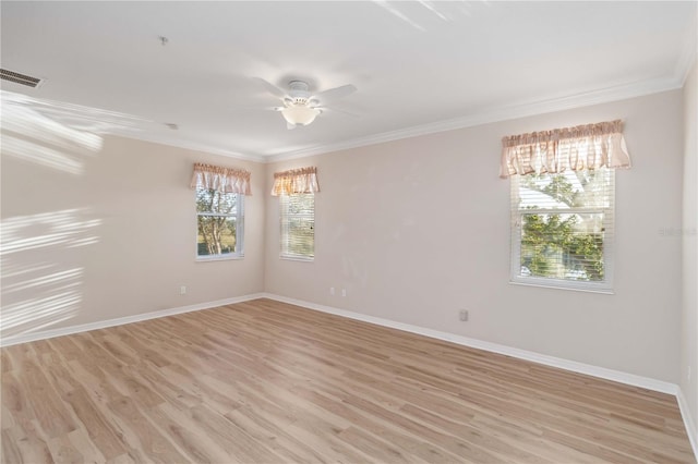 empty room with visible vents, baseboards, light wood-style floors, and crown molding