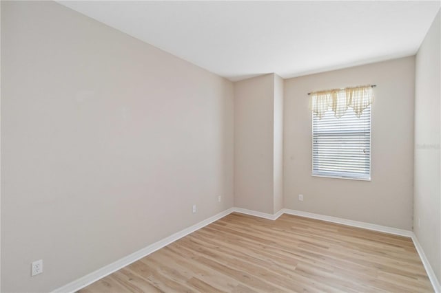 empty room featuring baseboards and light wood-type flooring