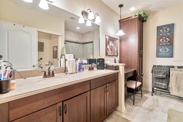 full bathroom featuring a tile shower, visible vents, double vanity, and a sink