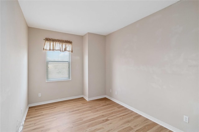 spare room featuring light wood-style floors and baseboards