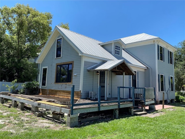 rear view of house with a lawn and a deck