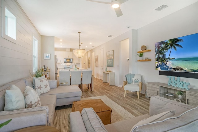 living room featuring a chandelier and light wood-type flooring