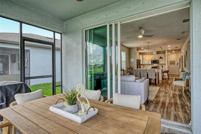 dining area with ceiling fan and wood-type flooring