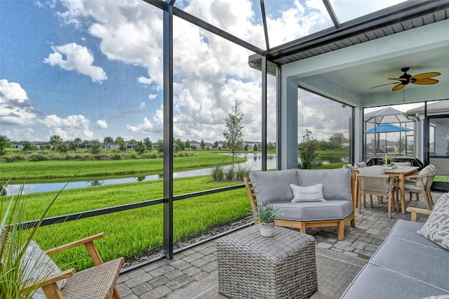 sunroom / solarium with a water view and ceiling fan