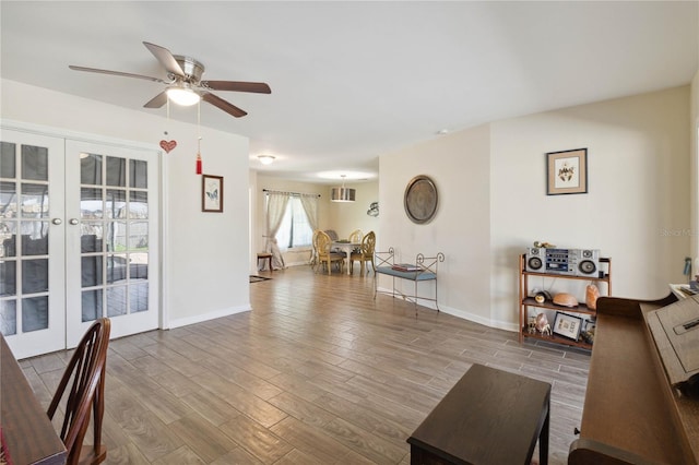 living room featuring ceiling fan, wood-type flooring, and french doors