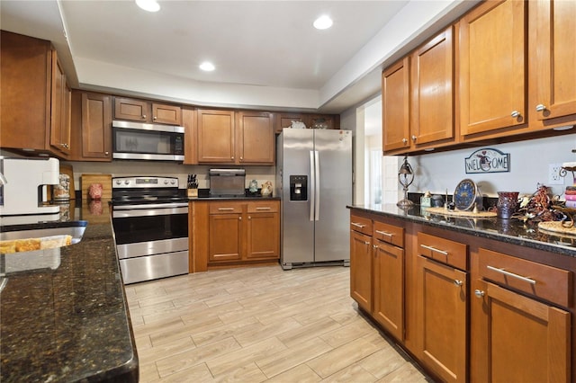 kitchen with dark stone countertops, sink, and stainless steel appliances