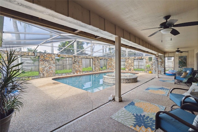 view of swimming pool with an in ground hot tub, glass enclosure, ceiling fan, and a patio area