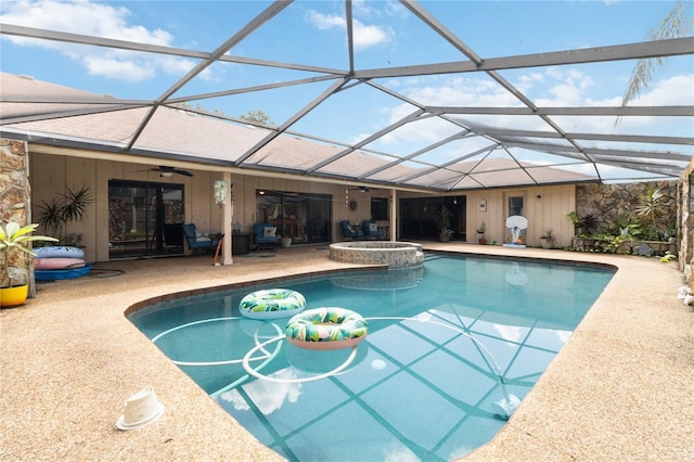 view of swimming pool featuring ceiling fan, a patio area, an in ground hot tub, and glass enclosure