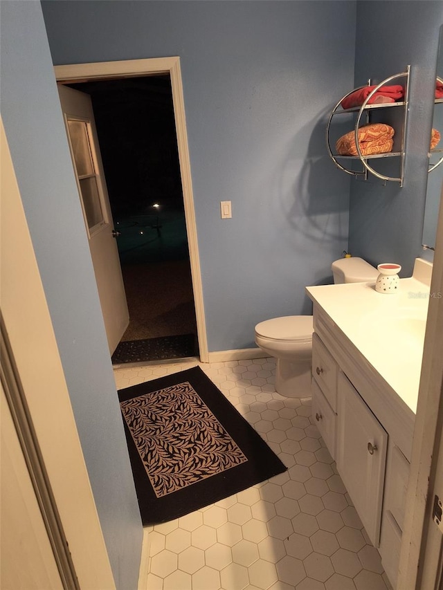 bathroom with toilet, vanity, and tile patterned floors