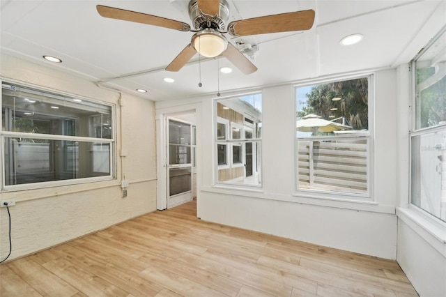 unfurnished sunroom with ceiling fan