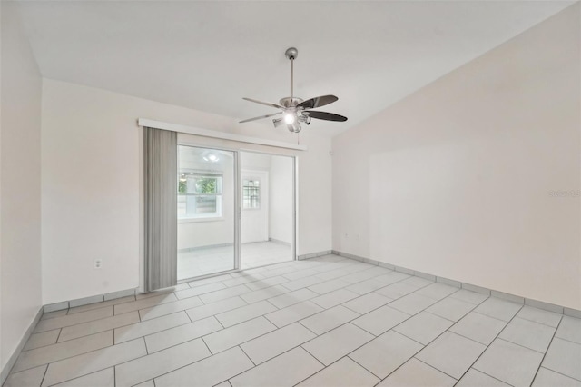 tiled empty room with vaulted ceiling and ceiling fan