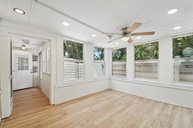 unfurnished sunroom with ceiling fan