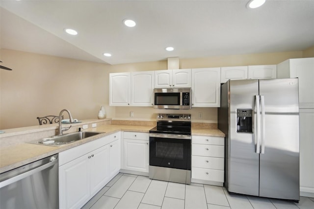 kitchen featuring lofted ceiling, sink, white cabinetry, and stainless steel appliances