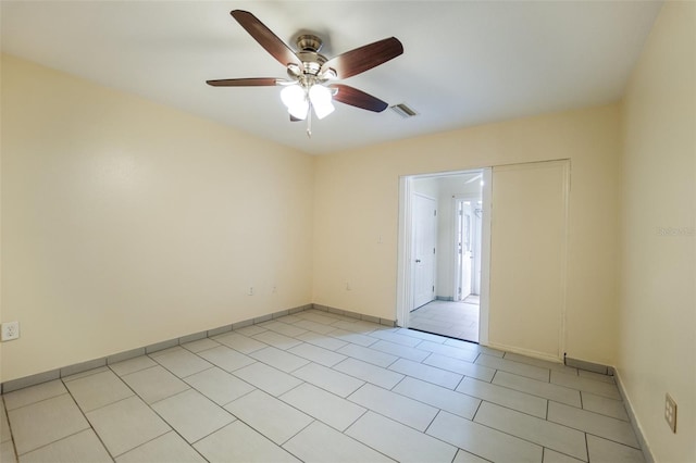 tiled spare room featuring ceiling fan