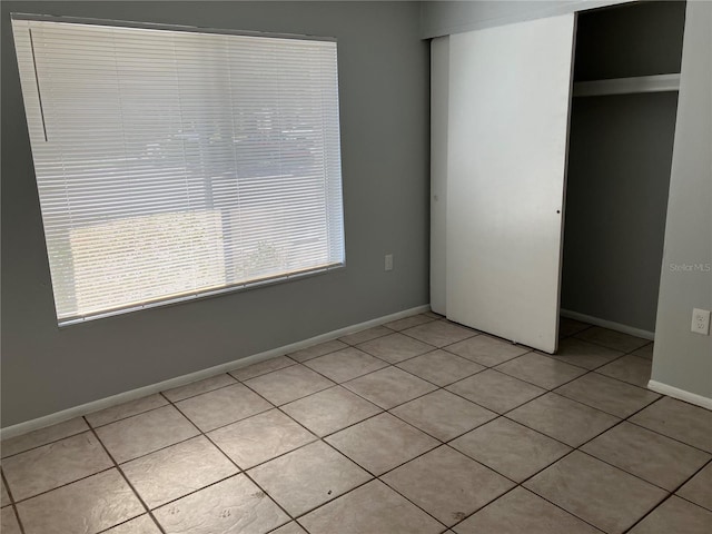 unfurnished bedroom with light tile patterned floors and a closet