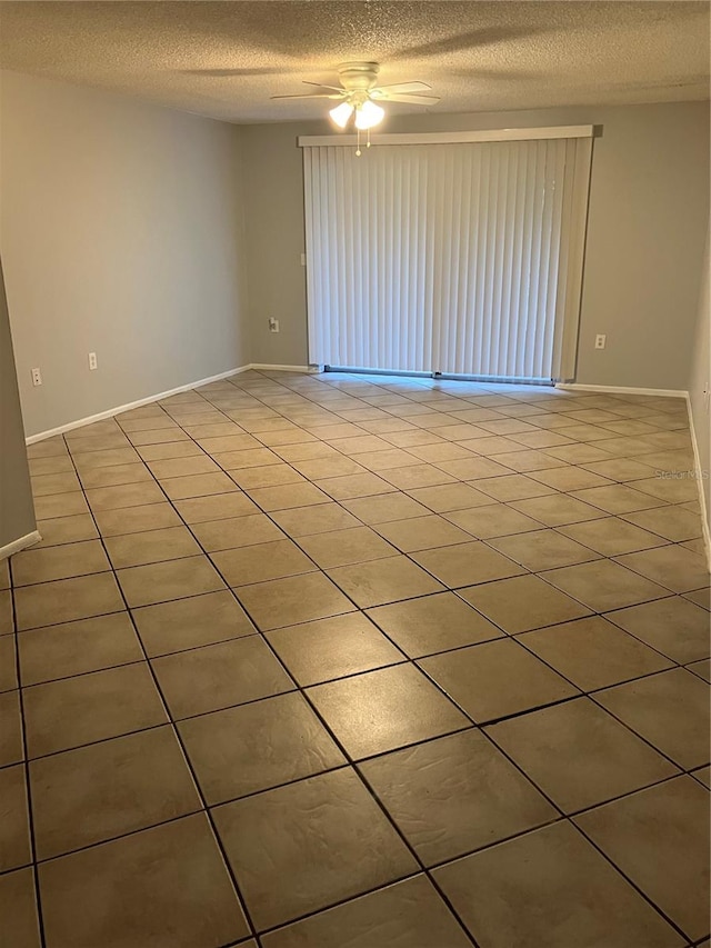 tiled empty room featuring a textured ceiling and ceiling fan