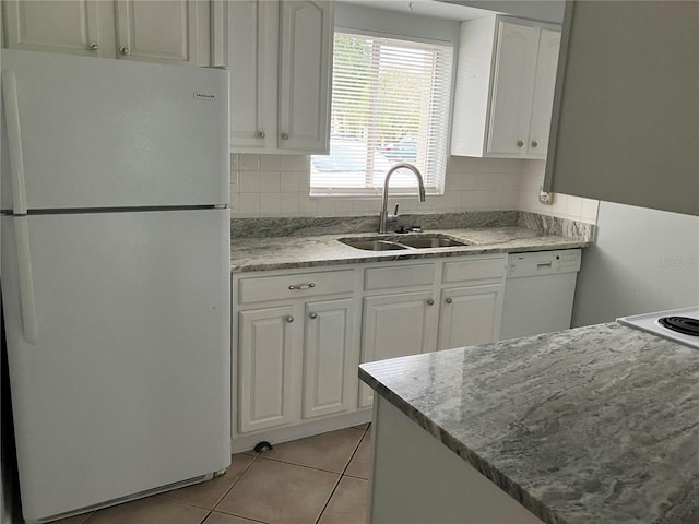 kitchen featuring white appliances, white cabinets, sink, decorative backsplash, and light tile patterned floors