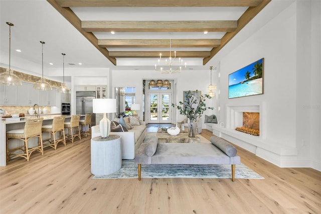 living room with french doors, sink, light hardwood / wood-style floors, an inviting chandelier, and beamed ceiling