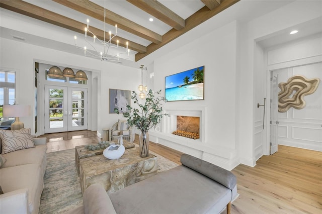 living room with light hardwood / wood-style flooring, french doors, a chandelier, and beam ceiling