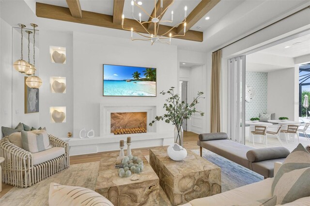 living room featuring light hardwood / wood-style floors, a chandelier, beam ceiling, and a premium fireplace