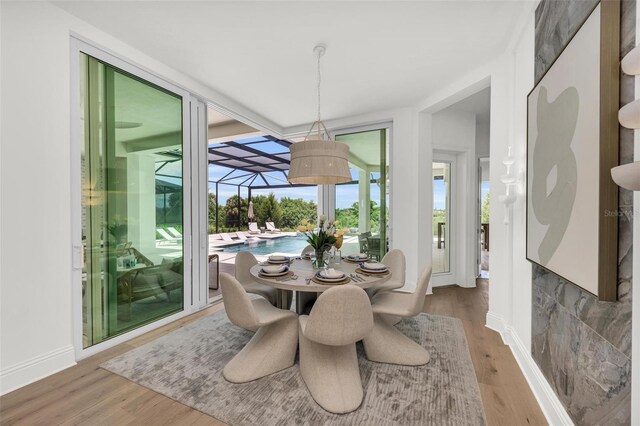 dining room with hardwood / wood-style floors and a wall of windows