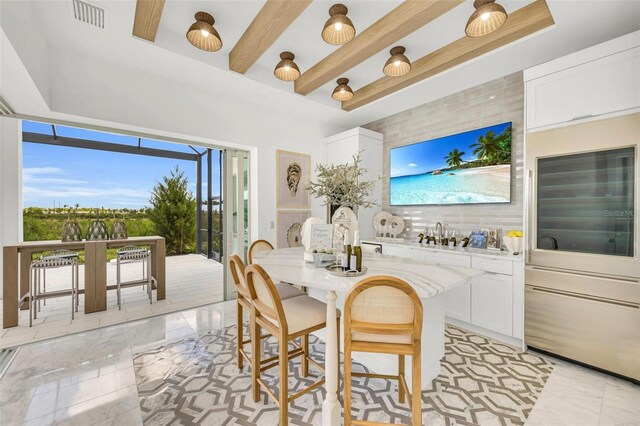 dining room with beverage cooler, beam ceiling, and french doors