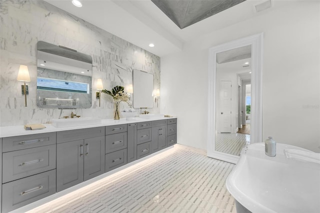 bathroom featuring a tub to relax in, tile walls, and vanity