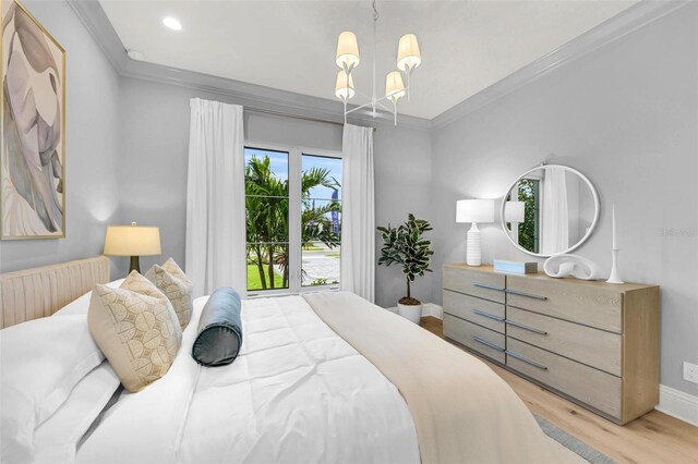 bedroom with light hardwood / wood-style floors, ornamental molding, and a chandelier