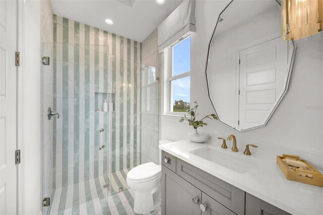 bathroom with a shower with shower door, toilet, and vanity