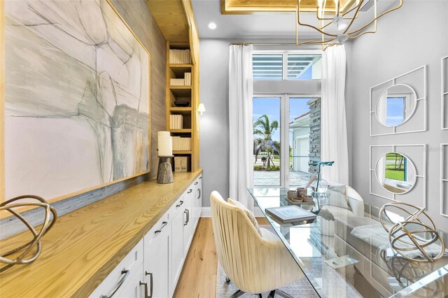 dining room with light wood-type flooring and an inviting chandelier