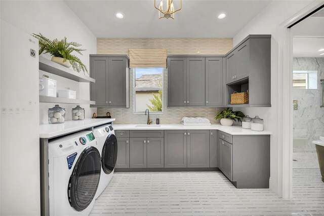 laundry room featuring sink, independent washer and dryer, and cabinets