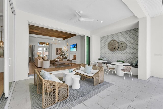 interior space with ceiling fan with notable chandelier and beamed ceiling