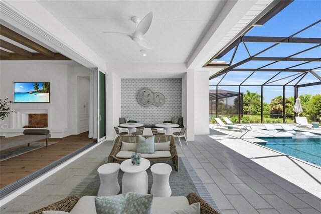 view of pool featuring ceiling fan, a patio area, and a lanai