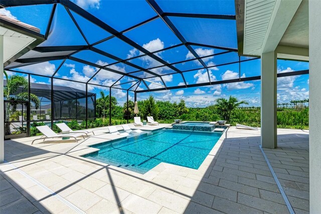 view of swimming pool with an in ground hot tub, a lanai, and a patio area