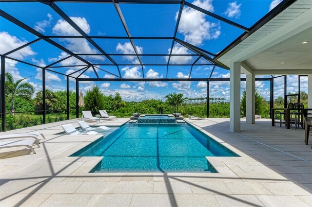 view of pool featuring an in ground hot tub, a lanai, and a patio area