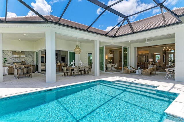 view of swimming pool with an outdoor bar, a lanai, and a patio