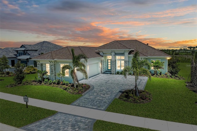 view of front of house with a garage and a lawn