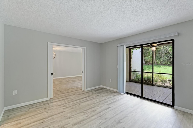 spare room featuring a textured ceiling and light wood-type flooring