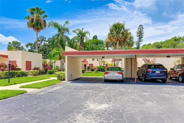 view of parking featuring a yard and a carport